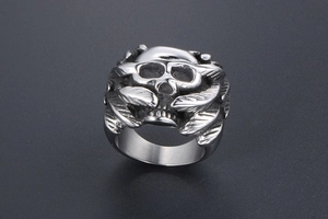 Detailed view of silver gothic skull ring with intricate wing carvings in polished steel