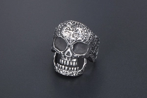 Macro detail of vintage silver skull ring featuring intricate floral scroll engravings