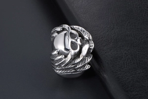 Detail view of gothic skull ring with silver wings and sunglasses for men