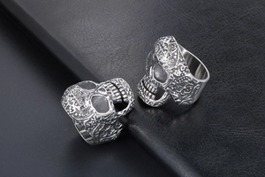 Macro shot of retro stainless steel skull rings with intricate gothic floral engravings