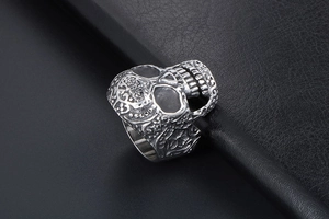 Detailed macro shot of vintage skull ring with embossed patterns on black leather