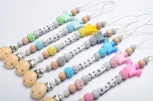 Detailed set of silicone and wood pacifier clips with crochet beads and crown charms