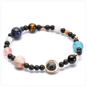 Close-up of solar system bracelet with natural stones and gold Saturn ring detail