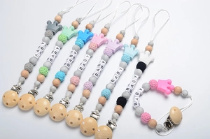 Detail of assorted silicone pacifier clips with baby letter beads and crown accents