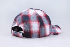 Detail of red and black plaid cotton baseball cap featuring adjustable strap and inner tag