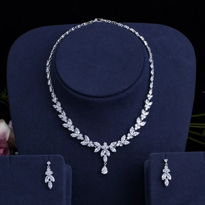 Detailed macro view of silver floral zircon necklace and earrings on blue velvet stand