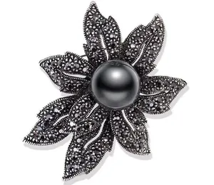 Macro shot of retro black pearl flower brooch with dark grey micro-pave crystals