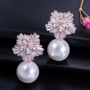 Detail of rose gold flower earrings with pavé zircon and white teardrop pearls