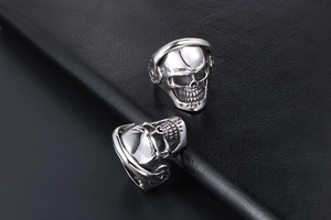 Macro detail of punk skull ring with headphones on black leather background texture