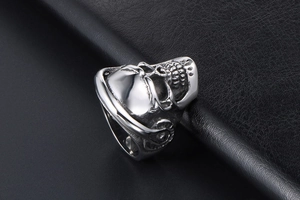 Detailed macro shot of silver skull ring with headphone design on black leather texture