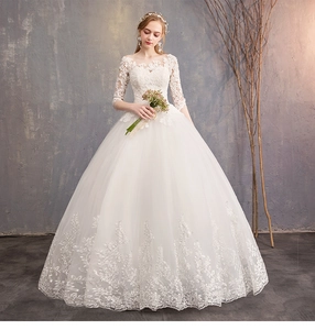 Detailed view of floral lace embroidery on the hem of a white ball gown wedding dress