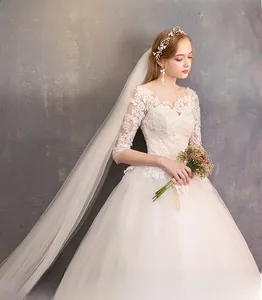 Detailed view of elegant white lace bridal gown with sheer sleeves and floral hair accessories