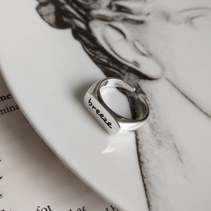 Detailed view of 925 sterling silver minimalist square ring engraved with breeze text
