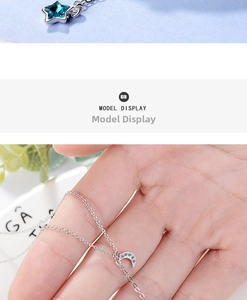 Detail of blue star and crescent moon necklace charms with silver link chain
