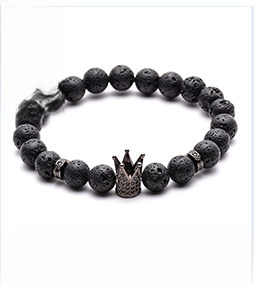 Macro shot of 8mm lava stone beads and micro-pave copper crown charm on bracelet