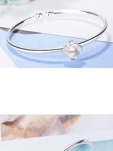 Dettaglio ravvicinato del bracciale a fiore argento con perla e finitura lucida