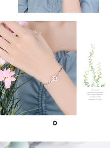 Bracciale loto in argento indossato con quarzo fragola rosa e ciondoli floreali chic