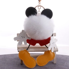 Detail of plush Mickey Mouse themed keychain with faux fur pom pom and gold metal ring