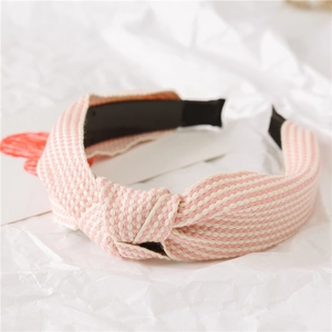 Nahaufnahme des rosa-weiß gestreiften Strick-Stirnbands mit stilvollem Knotendesign