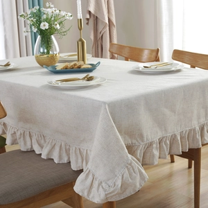 Elegante crèmekleurige linnen tafelkleed met ruches op een eettafel decor