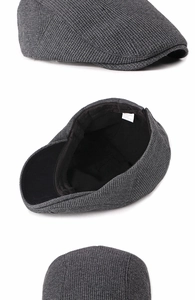 Detail view of dark grey knitted beret showing texture and inner black lining