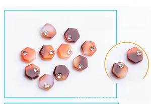 Detail of hexagonal nail art charms with marble texture and micro-inlaid rhinestones