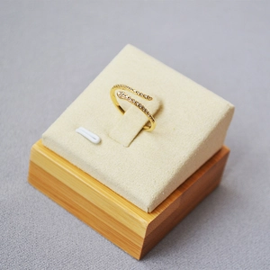 Elegant gold snake wrap ring with cubic zirconia stones on a beige velvet display