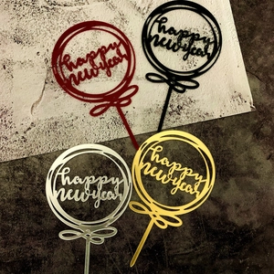 Vista dettagliata dei cake topper Happy New Year rotondi in rosso, nero, oro e argento