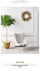 Detail of a frosted Christmas wreath with red berries and pine cones in a cozy room