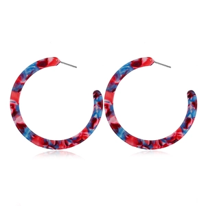 Close-up of red and blue marble textured acrylic C-shaped earrings with metal posts