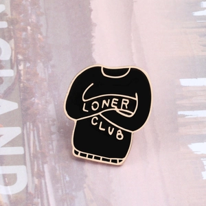 Detail of black enamel sweater brooch with Loner Club text and golden alloy edges