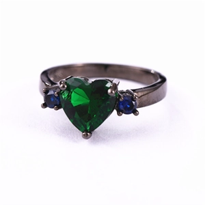 Black plated ring featuring green heart zircon and blue side stones on white background