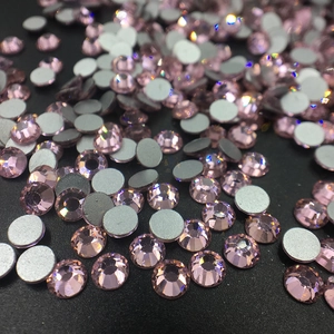 Macro view of pink flatback rhinestones for nail art showing faceted crystal and gray base