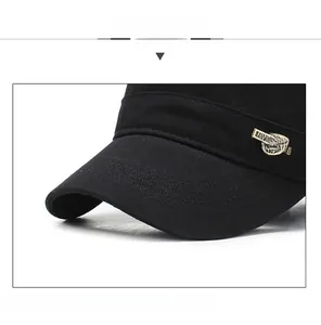 Detail of black military cap featuring a gold metal shield logo and thick cotton twill
