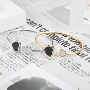 Double heart stainless steel bangle with gold and silver finishes and black enamel inlay