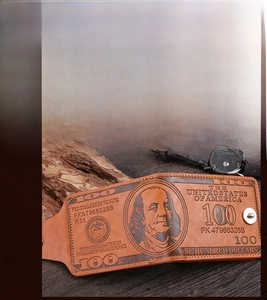 Detailed macro view of the vintage brown leather wallet with embossed 100 dollar pattern