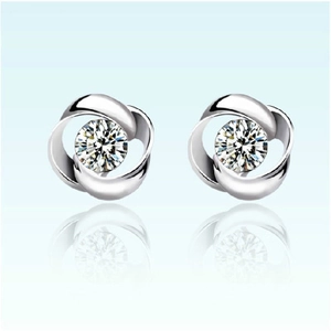 Macro shot of silver rotating flower stud earrings with a sparkling central zircon stone