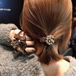 Detail of leopard print block and rhinestone circle pendant on elastic hair tie