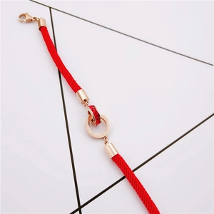 Rose gold interlocking ring bracelet with red cord and sparkling inlaid rhinestones