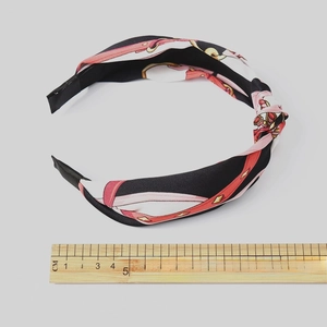 Satin knotted headband with chain pattern and ruler measuring the width 14cm