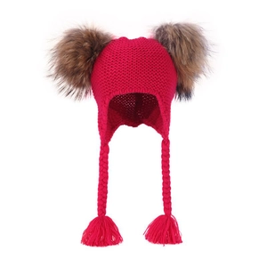 Detail of red cable knit winter hat for kids featuring large faux fur pom-poms and braids