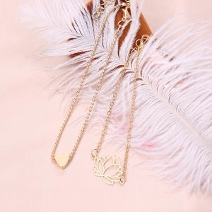 Ensemble de bracelets dorés avec cœur et lotus évidé sur fond de plumes blanches