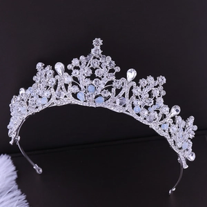 Close-up of bridal crown with sparkling rhinestones and opal stones on a dark background