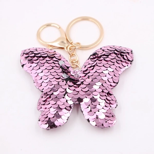 Pink sequin butterfly keychain with gold metal ring on a clean white background