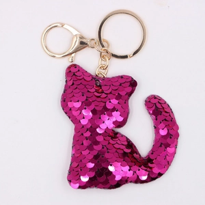 Macro detail of cat keychain featuring pink sequins and a shiny golden metal ring