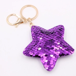 Detailed view of star-shaped keychain with shiny purple sequins and golden metal lobster clasp