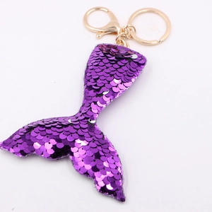 Sparkling purple sequin mermaid tail keychain with gold metal clasp on white background