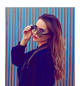 Detail of stylish oversized black sunglasses with reflective lenses on a model
