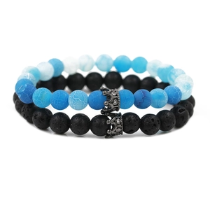 Macro detail of blue cracked stone and black lava beads with micro-paved crown charms