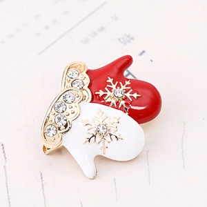 Macro detail of Christmas glove brooch with red white enamel and sparkling rhinestones